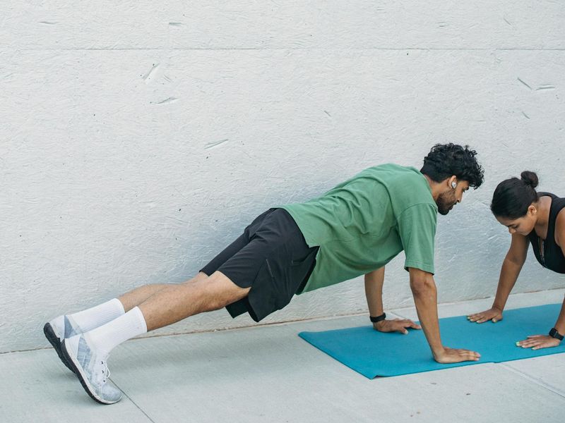 A focused man doing a plank exercise on a mat.