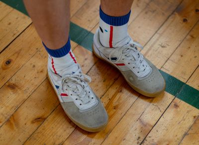 Close-up of athletic shoes on a wooden floor.