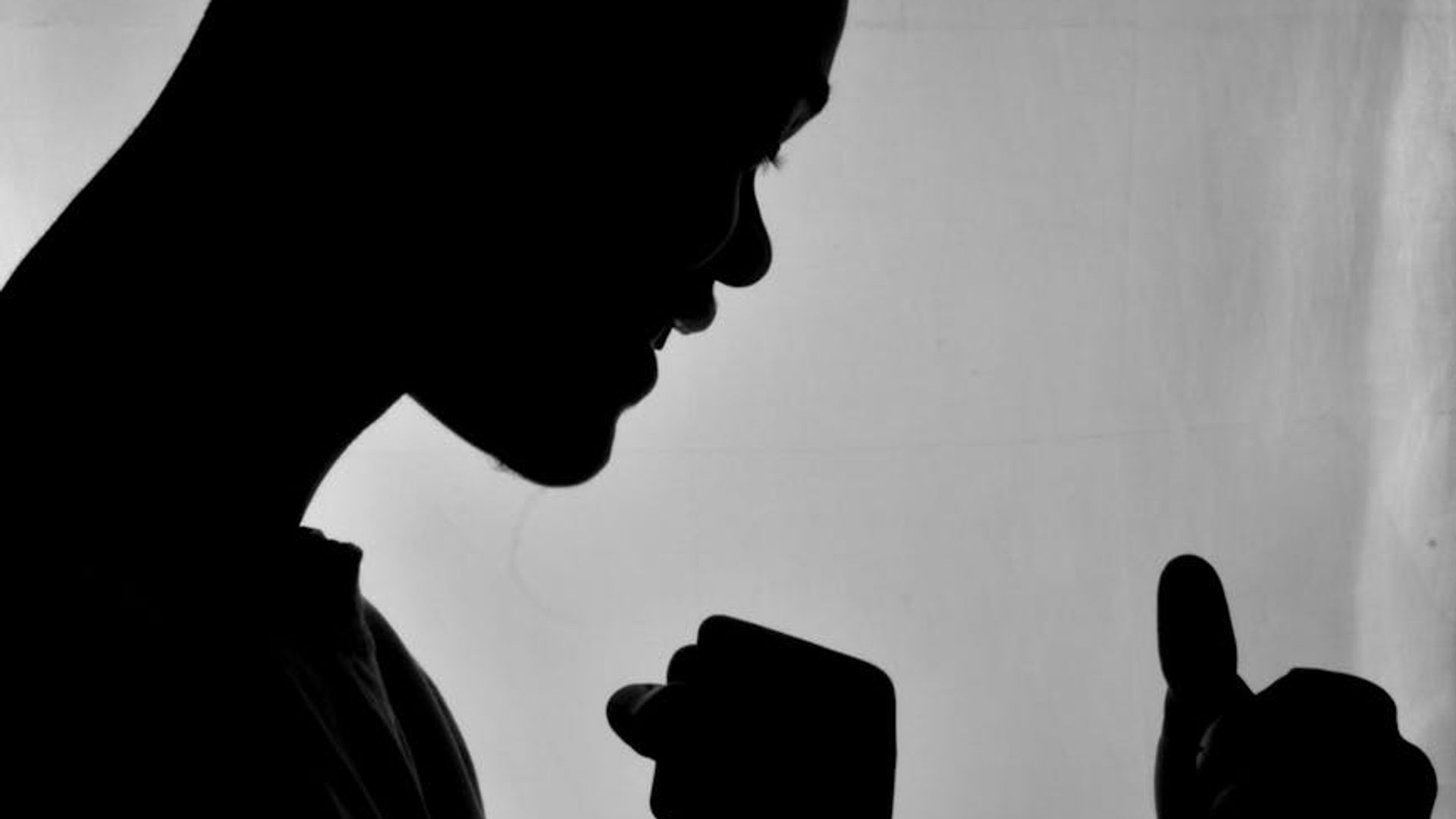 Silhouette of a man in a powerful athletic stance against a muted background.